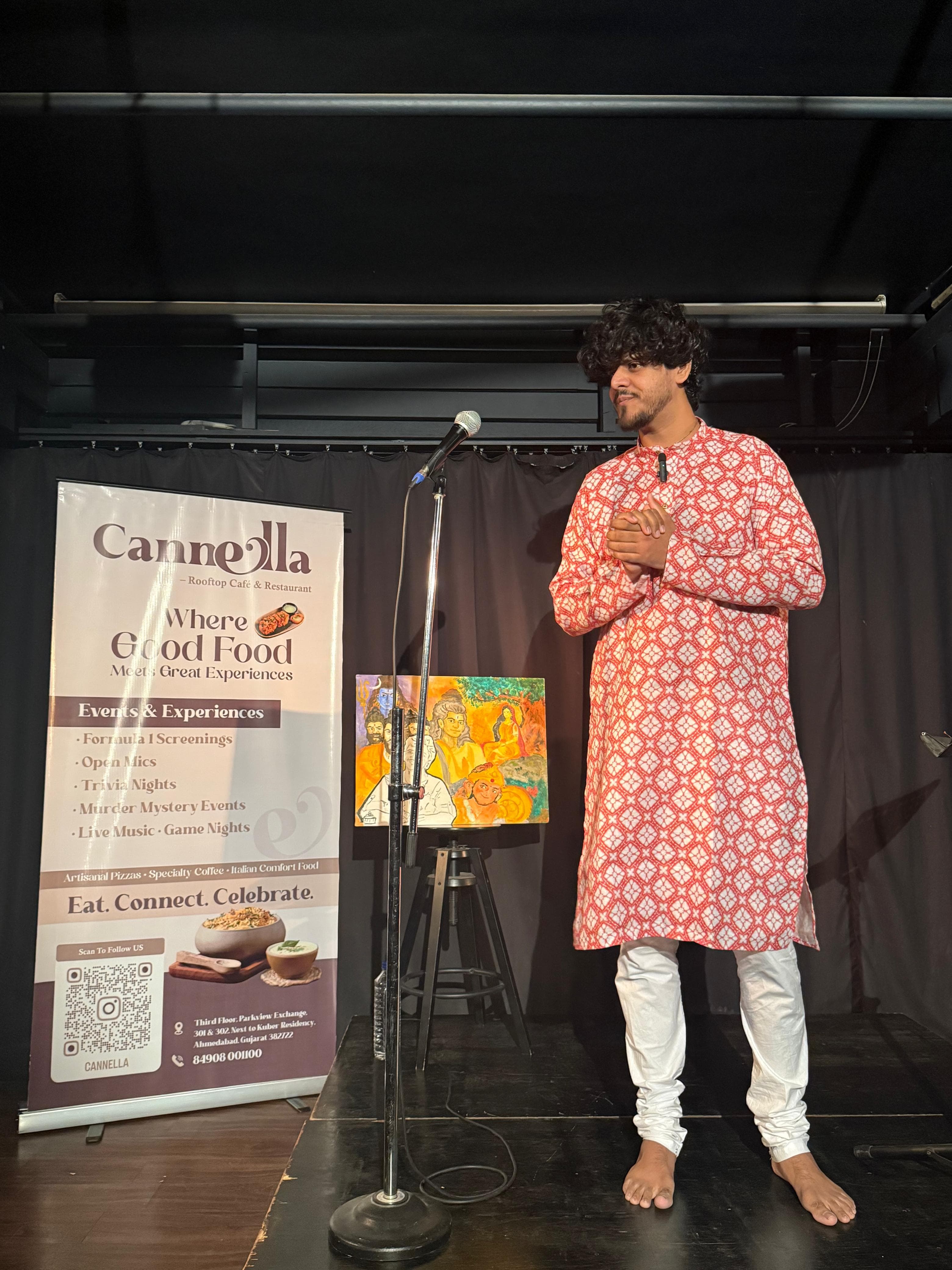 Badal beside the microphone and Ramayan artwork on stage